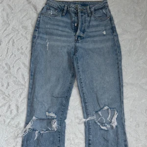 Ultra high waist mom jeans från H&M (strl 34) - Snygga ljusblå mom jeans från H&M med ultra high waist. Jeansen har raka ben, slitna detaljer och hål vid knäna. Klassisk femficksmodell i bomullsdenim med knappgylf. Skriv vid frågor 🥰