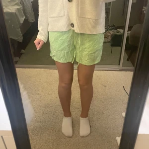 Ljusgröna shorts från H&M Divided XS - Säljer ett par ljusgröna shorts från H&M Divided i storlek XS. De har en loose passform, elastisk midja och snörning framtill. Materialet är mjukt och svalt, perfekt för varma dagar. Enkla och stilrena shorts som är lätta att matcha.
