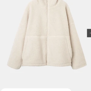 Beige teddyjacka från Carin Wester - Mysig och oversized teddyjacka i beige med hel dragkedja framtill och stora fickor. Perfekt för kalla dagar när du vill vara både varm och stilren. Jackan har lång ärm och en fluffig, mjuk känsla.