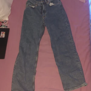 Blå raka jeans från WIN, XS - Klassiska blå jeans från WIN i storlek XS. Jeansen har raka ben, normal passform och traditionella fickor både fram och bak. Tillverkade i slitstarkt denim med snygga kontrastsömmar. Perfekta för dig som gillar en enkel och tidlös look.