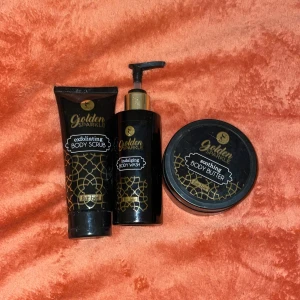 Golden Sparkle kroppsvård set - Lyxigt set med exfolierande body scrub, body wash med pump och återfuktande body butter. Alla produkter kommer i snygga svarta och guldiga förpackningar med elegant mönster. Perfekt för dig som vill ha en glittrig och fräsch känsla i din hudvårdsrutin. Helt oöppnade💓