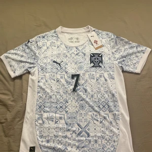 Portugal Ronaldo #7 fotbollströja - Portugal fotbollströja från Puma med Ronaldo och nummer 7 på ryggen. Tröjan är storlek S, män. Den är helt ny och aldrig använd. Skickar inom 1-3 dagar