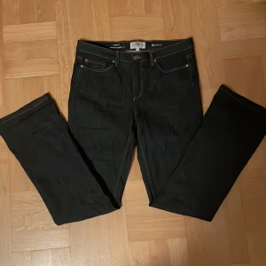 Mörkblå bootcut jeans Hampton Republic - Mörkblå jeans från Hampton Republic 27 med bootcut-snitt och klassisk femficksdesign. Jeansen har kontrastsömmar, knapp och dragkedja framtill samt detaljerade nitar. Materialet är jeans och midjan är normal. Perfekt för dig som gillar en tidlös look. Dom är i jättefint skick och säljer då det inte är min stil💕💕