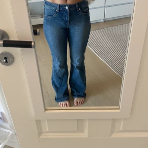 Blå bootcut jeans - Snygga blå jeans med bootcut passform och hög midja. Klassisk femficksmodell med knapp och dragkedja framtill. Är i storlek 36 och är från HM