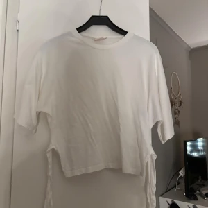 Vit knyt topp - Säljer en jättefin vit knyt topp från Nelly som inte kommer till användning längre den är använd 1-2 gånger