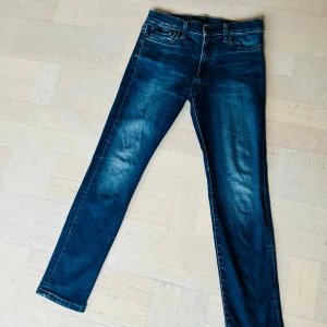 Ralph Louvren byxor - Snygga mörkblå skinny jeans med klassisk femficksdesign och kontrastsömmar. Jeansen har en smal passform och är tillverkade i stretchigt denim för extra komfort. Perfekt för dig som vill rocka i vinter! Priset är inte hugget i sten!