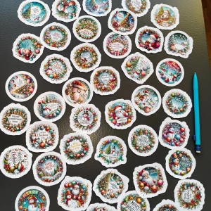 45 at Julklistermärken Merry Christmas 2026 4.5 cm - 45 at Färgglada julklistermärken med motiv av tomtar, snögubbar och julgranar. Perfekt för paket, kort eller dekoration. Klistermärkena är i nyskick, ingen synlig skada eller slitage. Innehåller flera olika motiv med texten 'Merry Christmas 2026'.