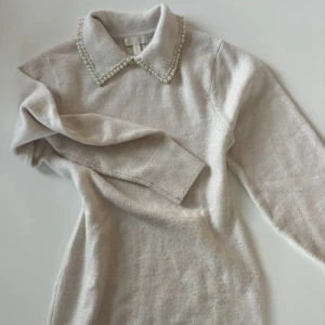 Stickad klänning med pärlor - Sååå söt och snygg!! Det är en ullblandning och håller en varm! Kan stylas som miniklänning eller som en längre tröja med byxor