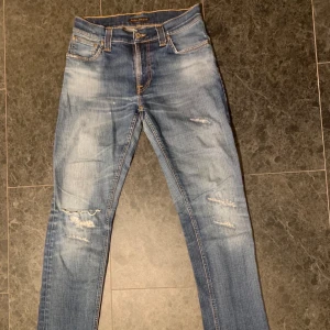 Nudie jeans med slitningar - Tja! Säljer ett par feta Nudie Jeans med snygga slitningar. Storlek W29 L32. Hör av er vid eventuella frågor.