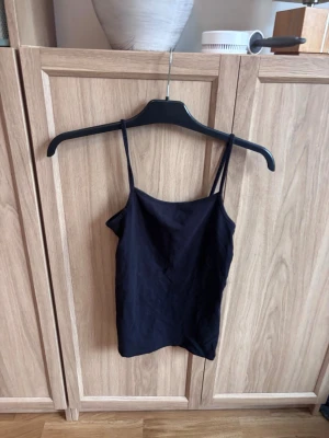 Svart linnetopp från H&M - Säljer en enkel och stilren svart linnetopp från H&M. Texten med storleken har suddats bort, men jag tror att det är 158/164 eller 170