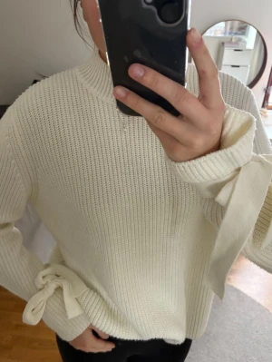 Stickad tröja  - Stickad tröja med knutar på armleden 