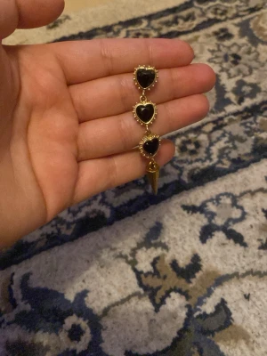 Maria Nils dotter liknade smycke - Ett smycke med svarta hjärtan och guldfärgade detaljer. Maria Nils dotter liknade SÄLJER BARA ETT