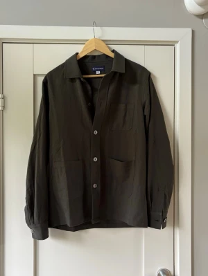Mörkgrön overshirt - Helt ny olivgrön overshirt från ST studios. Nypris 1895kr säljer den nu för endast 699kr. Storlek S passar även M. Ingår ett par helt nya solglasögon vid köp :)