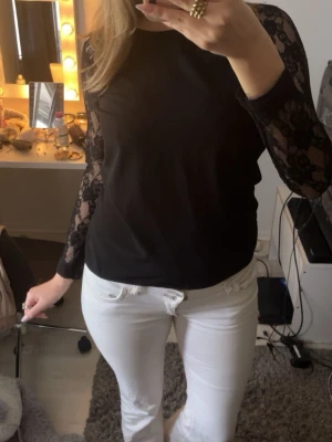 Svart tröja med spetsärmar - svart tröja med långärmade spetsärmar i blommigt mönster. Väl omhändertagen❤️