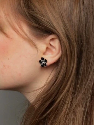 Vintage örhängen - Söta blommor som örhängen i svart emalj och med strass. Köpta begagnat och antar att de är vintage. 