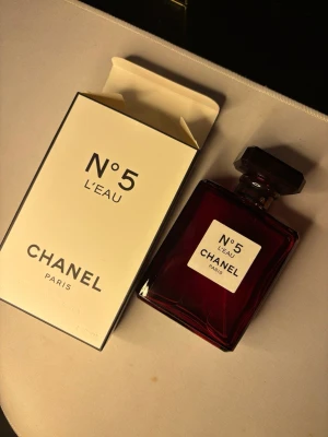 Chanel N°5 L'Eau röd flaska - Chanel N°5 L'Eau i en unik röd flaska. En ikonisk parfym från Paris som sticker ut och ger din stil en exklusiv touch. Volym: 3.4 FL OZ.