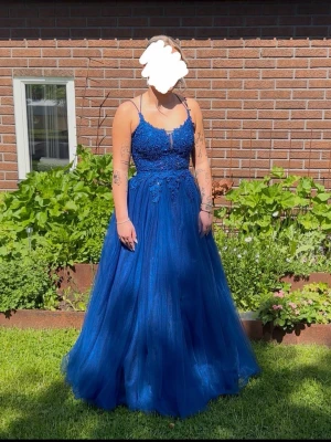 Klarblå balklänning  - Dags att sälja min älskade balklänning 💙          Köpt ny på Ruths i Västerås för 6 000 kr. Använd en gång på bal 2025, i mycket fint skick utan defekter. Förvarad i tillhörande klädpåse (ingår).  Den har spets med små pärlor på överdelen som gör att den skimrar fint i solljuset. Storlek 36 men kan justeras i storlek tack vare snörningen i ryggen. Jag är 165 cm och bar 8 cm klackar och då var den i perfekt längd. Jag hade en underkjol som jag hyrde men klänningen funkar lika bra utan underkjol.