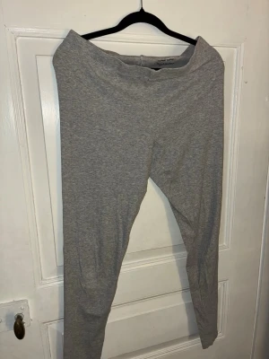 Grå nightwear leggings från Mywear Woman - Grå nightwear leggings från Mywear Woman i storlek L. Leggingsen är enkla och mjuka med en smal passform och resår i midjan. Perfekta för chill dagar hemma eller när du vill sova extra bekvämt. Tillverkade i bomullsmix för en skön känsla.