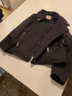 Snygg gråsvart jacka  - Mjukt tyg, känns lent. Snygg modell, lämplig som fint ytterplagg vår och höst 