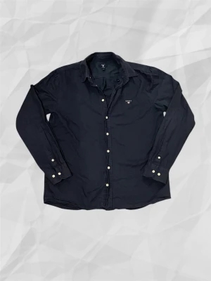 Gant skjorta - En stilren och klassisk marinblå skjorta från Gant, som passar perfekt till alla olika möjliga outfits, den är ej använd många gånger alls och är i bra skick, skriv för mer bilder eller funderingar, Mvh Holmbergsresell