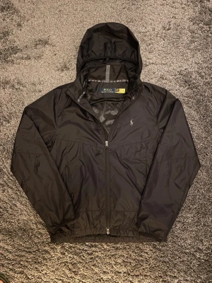 Ralph Lauren Vindjacka med vikbar luva - Knappt använd ✅ Den har en luva som går att gömma, se bilderna. Dubbel dragkedja Fraktar inom en dag 🚚 Skicka gärna rimliga prisförslag!               Skriv om du har frågor 
