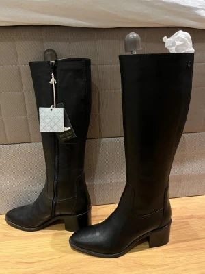 Svarta stövlar från Dasia med klack - Snygga svarta stövlar från Dasia med stilren design och spetsig tå. Stövlarna har en låg klack och dragkedja på insidan för enkel på- och avtagning. Aldrig använda, kostar 2400kr i nypris (se sista bilden😊). Kom med prisförslag