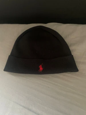 Svart mössa från Polo Ralph Lauren - Hej säljer nu min Ralph Lauren mössa pga den inte kommer till användning mössan är i storlek one size och hör av er om mer frågor