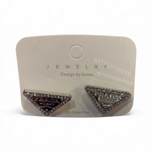 Triangelformade örhängen med strass - Snygga triangelformade örhängen f med glittrande strass runt kanterna . Örhängena är silvriga och har en cool, lyxig vibe som verkligen sticker ut. Perfekta för dig som gillar statement-smycken och vill ha något unikt.