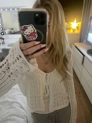 Mönster Stickad kofta  - Mönster stickad tröja från Bikbok i xs, använd fåtal gånger. Har super söta rosetter framtill som man ser på bilden. Passar perfekt till över ett linne å styla eller slänga över bikinin till stranden 🪷 Skriv för frågor pris kan självklart diskuteras!!