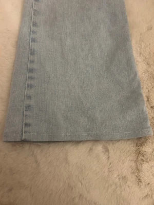 Ljusblå jeans Nelly  - Ljusblå lågmidjade jeans från Nelly med rosa detaljer på fickorna i storlek 32. Jag har sytt upp längst ner i benen då de va för långa men det kan man enkelt sprätta bort om man vill ha de i vanliga längden igen. Jag är 162 så benen var rätt så långa.