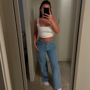 Blåa wide jeans med hög midja - Blåa jeans med hög midja och raka, vida ben. Lite stretch och köpta på H&M. Jag är storlek 36 men jeansen är 38 och passade mig när jag var 38 också.