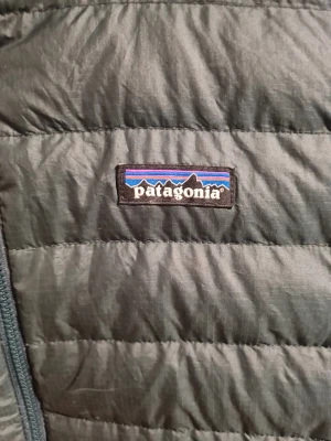 Patagonia Men's Down Sweater hoody - Säljer en mörkgrön lättvikts dunjacka Från Patagonia i storlek Small, jackan är väl använd men väl omhändertagen utan defekter, hål, fläckar och alla dragkedjor fungerar som dom ska.. Nypriset ligger på runt 3300:- svenska kronor i dagsläget