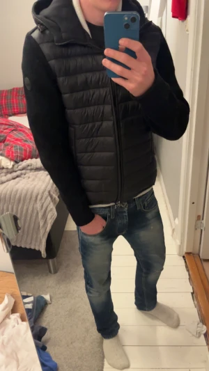 Svart cardigan jacka från colmar  - Svart cardiganjavka från Colmar med snygg huva och quiltad front. Jackan har dragkedja, stickade ärmar och sidofickor med zip. Perfekt för dig som gillar en clean och sportig look. Materialmix av polyester och stickat som håller dig varm och snygg, perfekt för det kallare halvåret!😁hör av er vid funderingar🤗🤗