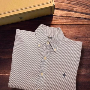 Randig skjorta från Ralph Lauren XS -  Storlek: XS Färg: Vit / Blå Skick: 8/10 (litet ej synligt hål på baksidan) Passform: Slim Fit Material: 100% bomull 📦Skickar så fort som möjligt. Skriv om du har frågor.