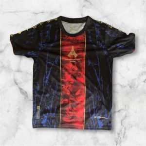 Svart och röd fotbollströja Paris - Unik fotbollströja med svart bas, röda och blå detaljer samt guldiga inslag. Framsidan har ett rött vertikalt fält med ornament, blått marmormönster och guldfärgat tryck med texten 'European Champions 31.05.2025'. Rund hals och korta ärmar.