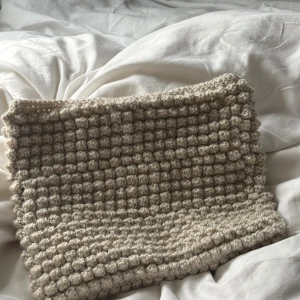 Beige virkat datafodral med bubbelstruktur - Superfin beige virkat datafodral med unik bubbelstruktur som ger en cool och trendig look. Datafodralet är handgjort och har en mjuk, chunky känsla som passar perfekt till en chill outfit. Måtten är ca 30 x 25cm. Garnet är elastiskt så det passar till de flesta datorerna 