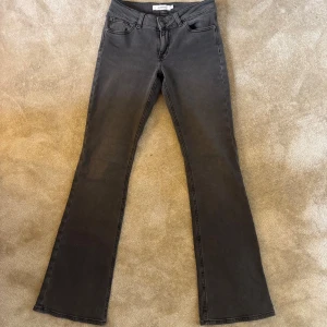 Svarta bootcut jeans från Junkyard S - Snygga svarta/gråa lågmidjade bootcut jeans från Junkyard i storlek S. Innerbenslängd 83 cm.  Använda max 3 gånger🙌 