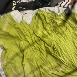 Ljusgrön långklänning från H&M XS - Säljer en flowy ljusgrön linnebyxor från H&M i storlek XS. byxorna har resår i midjan och knytband framtill för en snygg passform. Perfekt för varma dagar med sitt tunna och svala material.