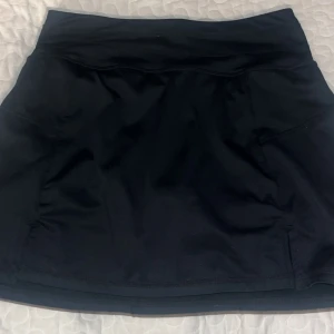 Svart tennsikjol  - Svart sportig kortkjol med enkel design och bred midjeresår.  Från soc