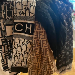 Designerhalsdukar från Fendi & LV - Flera lyxiga halsdukar med ikoniska logomönster från Fendi, Louis Vuitton och CH. Färgskalan går i svart, beige och brunt. Perfekta accessoarer för att lyfta din outfit med exklusiv känsla och trendig design. Fendi (vit/svarta) 200kr Fendi (beige) 150kr lv (gråa) 150kr dior (vit/svarta) 350kr