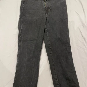 Svarta raka jeans - Svarta jeans med klassisk femficksdesign och raka ben. Jeansen har normal midja och dragkedja framtill. Perfekta för en avslappnad och stilren look. Materialet är jeans i bomull med en något mörk tvätt.