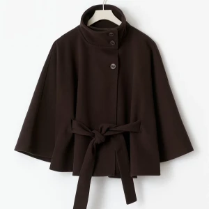 Mörkbrun cape-kappa med bälte från Gina Tricot - Snygg mörkbrun cape-kappa med hög krage, knappar framtill och brett knytbälte i midjan. Jackan har vida ärmar och en stilren. Perfekt för dig som vill ha en trendig jacka. Ny pris 499kr från Gina Tricot.