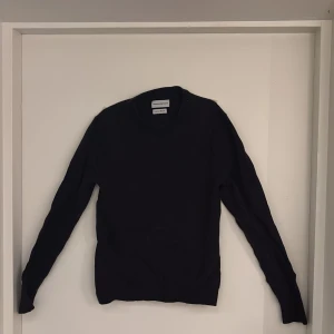 Svart merinoullströja These Glory Days - En stilren svart tröja från These Glory Days i mjuk och lyxig merinoull. Klassisk rund halsringning och långärmad modell som passar perfekt till lager-på-lager. Enkel och clean design som funkar till allt.