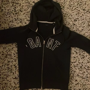 Gant tröja blå - En väldigt stilren mörkblå gant tröja i storlek xs ( för barn) passar nog någon runt ca 146-152 cm. Som sagt en snygg tröja men ena nackdelen är ett hål vid slutändan på ärmen. Kan säkert sys. Om ni vill ha bild på hur den sitter på så är det bara att fråga:)