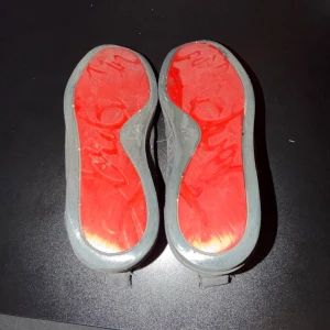 Grå Loubs  - Snygga sneakers i grå mocka med rund tå och snörning. Insidan är beige och yttersulan är riktigt cool med röd färg och signaturdetalj. Perfekt för dig som gillar stilrena skor med en twist. Skorna har platt sula och diskret design som funkar till många outfits.