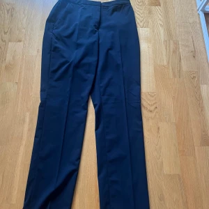 Svarta kostymbyxor från H&M - Snygga mörkblå kostymbyxor från H&M med klassisk rak passform och dold dragkedja. Mid/low waist💌