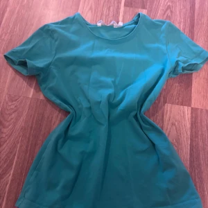 Turkos t-shirt från JoyLove - En enkel turkos t-shirt från JoyLove med rund halsringning och korta ärmar. Perfekt till jeans eller shorts för en avslappnad stil. Gjord i mjukt material som känns skönt mot huden.