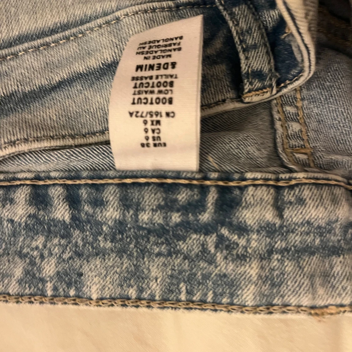 Bootcut ljusblå jeans med slitning - 1
