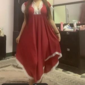 Röd långklänning med spetsdetaljer - ((priset kan diskuteras)) Röd långklänning med v-ringning och vita spetsdetaljer vid halsringning och ärmar. Nattklänningen har lös passform och är ärmlös med breda axelband. Perfekt för dig som gillar romantiska och feminina plagg. (Köpt utomlands, ej använd alls). 