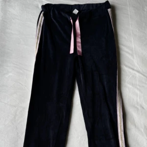 Mörkblå mjukisbyxor - Mörkblå mjukisbyxor i sammet från Uniq Young med rosa satinband i midjan och har dekorativa ränder längst sidorna, i storlek 146. Fraktar inom 24h!